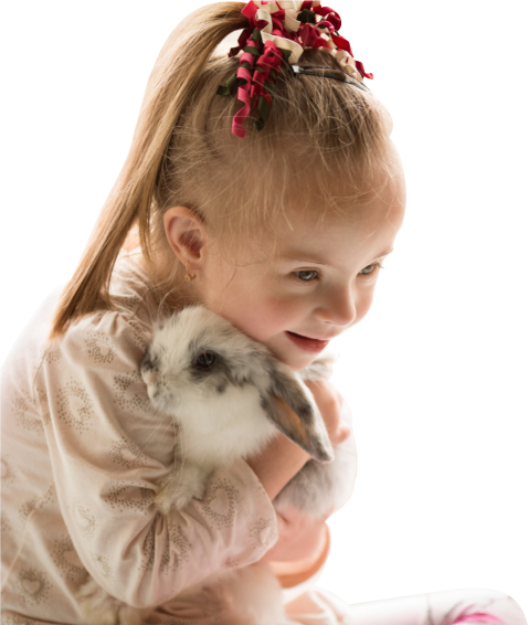 a little girl hugging her rabbit