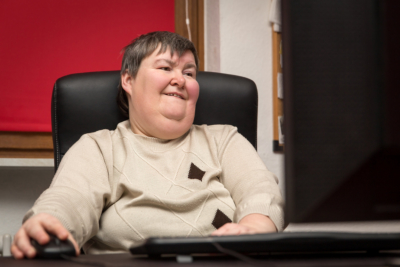 Woman with a disability develop sitting at the computer